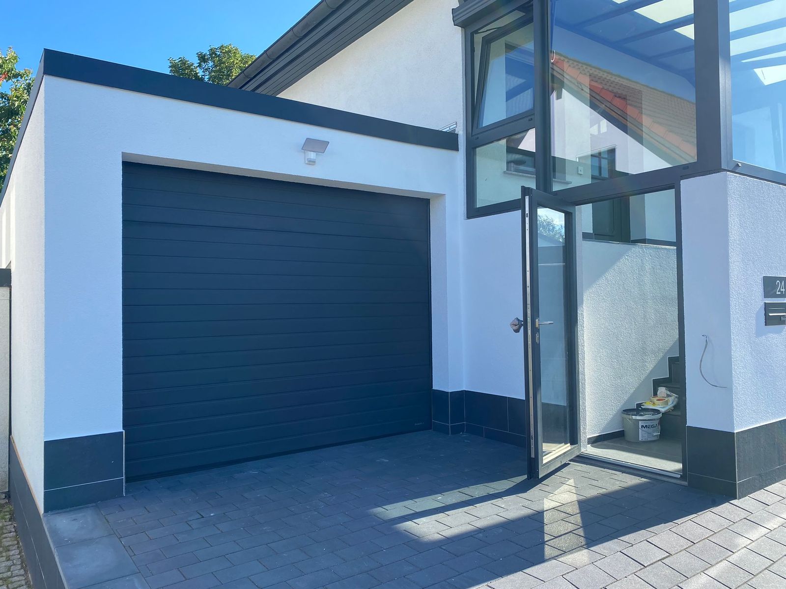 Fertiggestellte Garage mit Sektionaltor und gepflasterter Hofeinfahrt