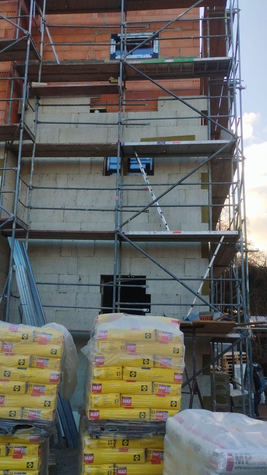Porenbeton-Mauerwerk im Rohbau mit angeliefertem Baumaterial