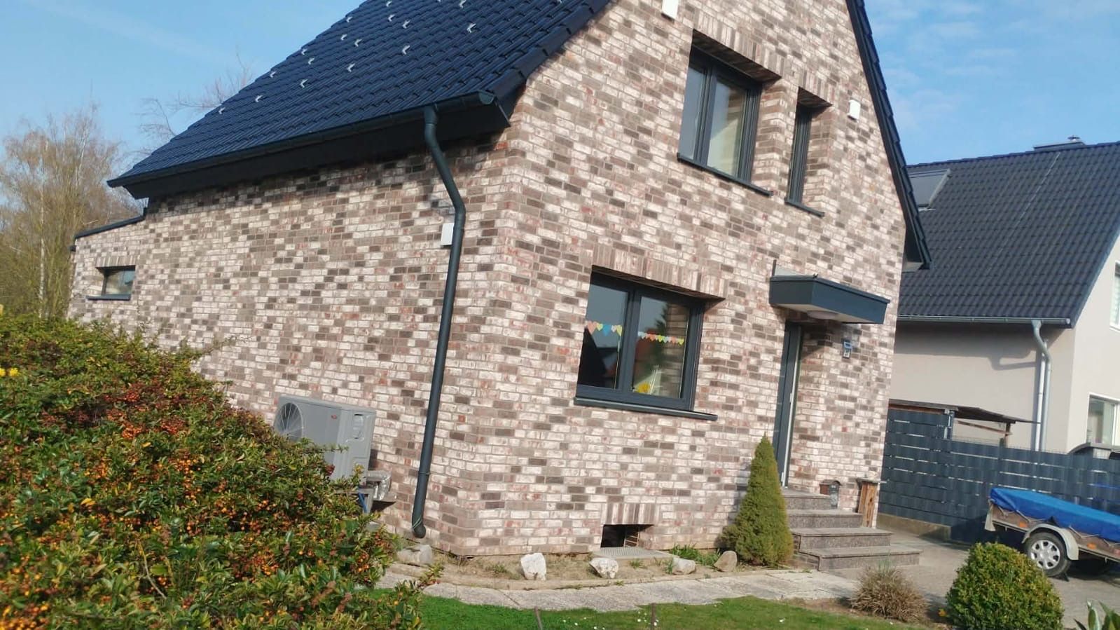 Fertig erstelltes Wohnhaus mit Natursteinfassade – Neubau von Projekt Bau GmbH