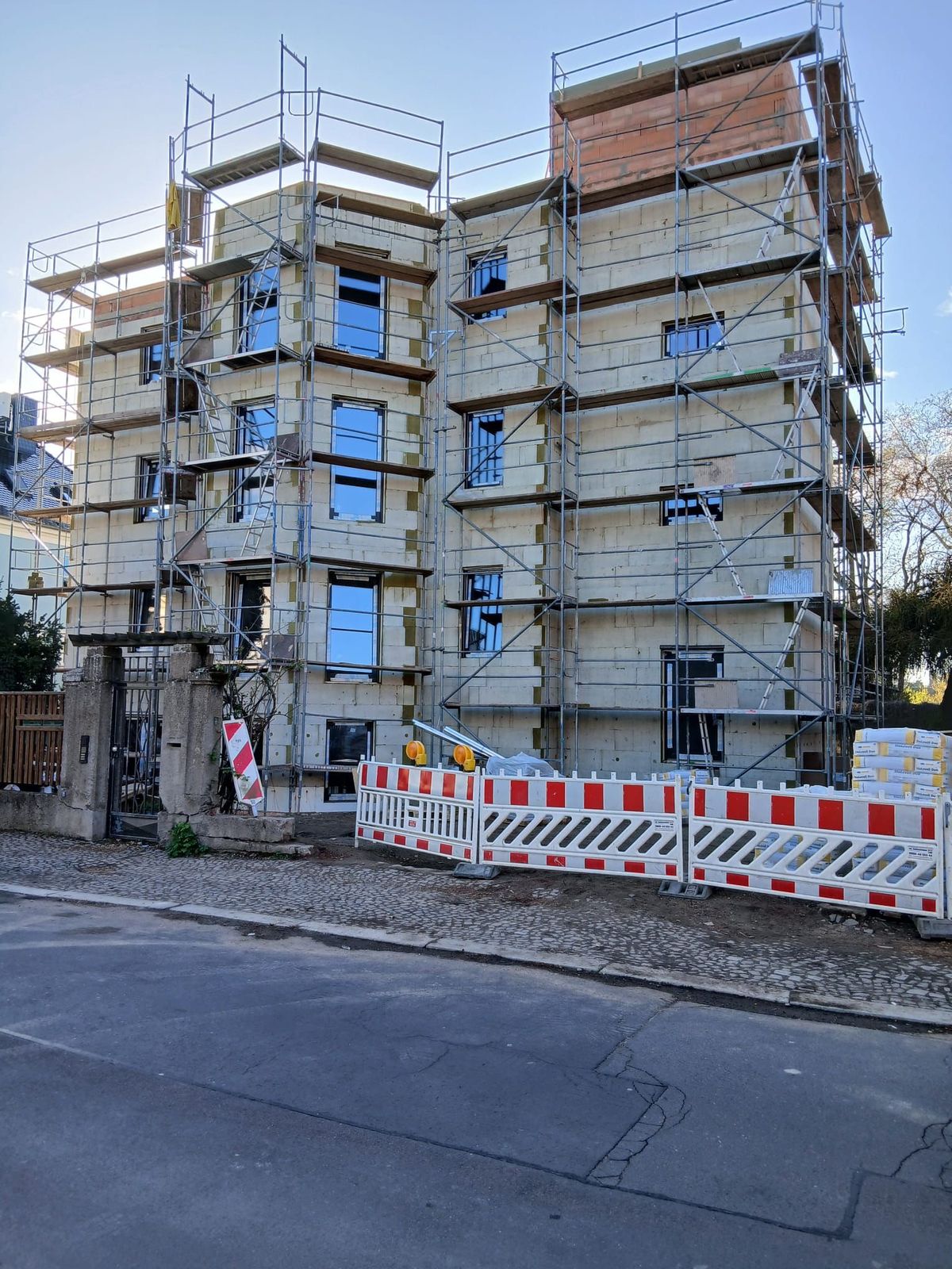 Fassadenarbeiten am eingerüsteten Stadtgebäude mit Baustellenabsicherung