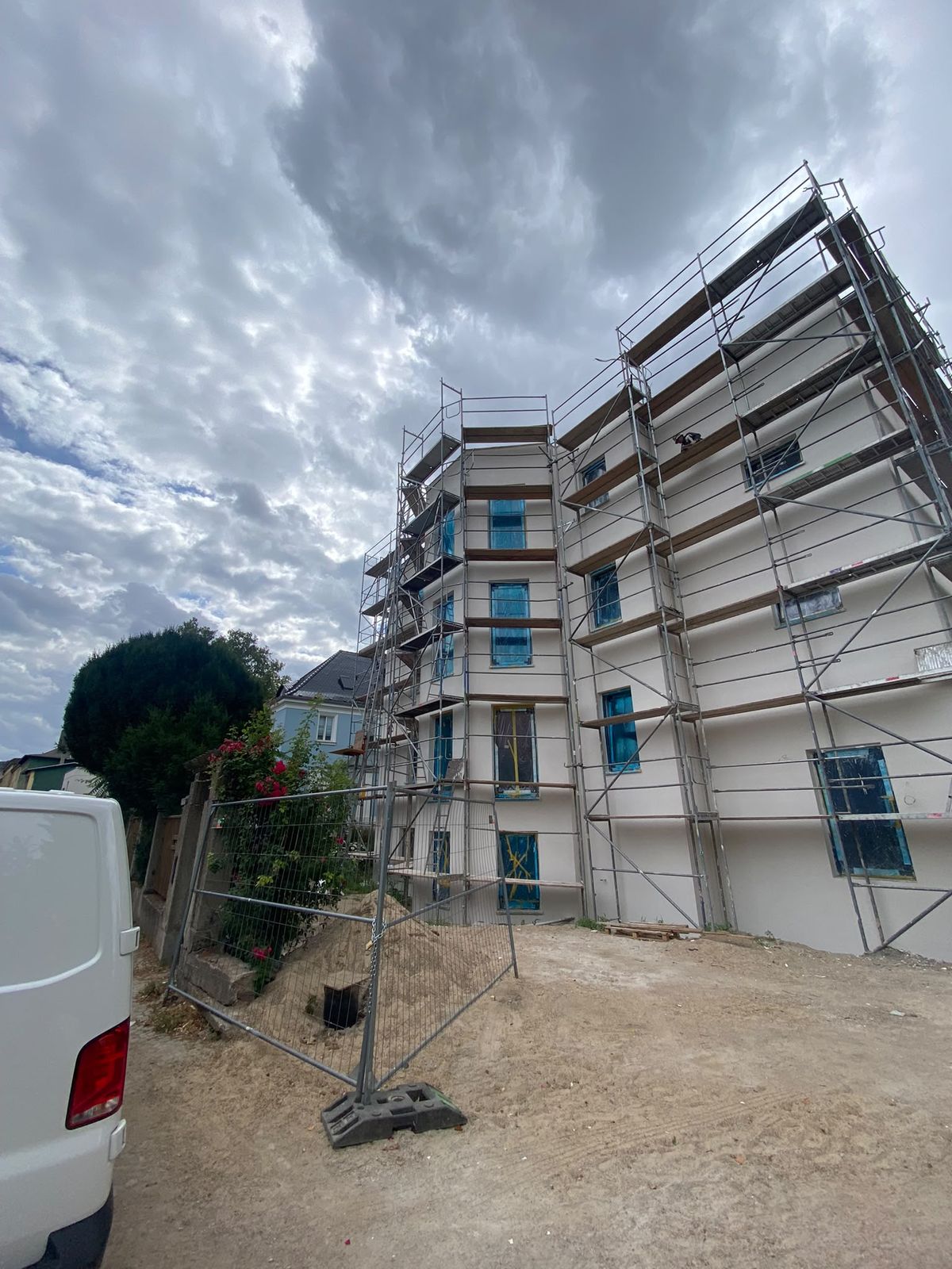 Mehrfamilienhaus bei der Sanierung – Fassade mit Dämmung unter dem Gerüst